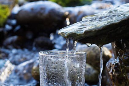 Natural drinking water is being poured into glass