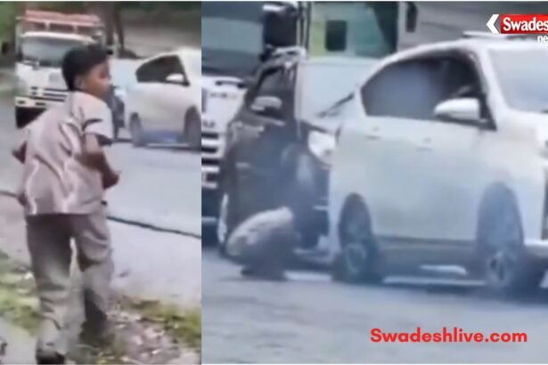 A young boy stops a rolling car by placing a stone under its tyre, preventing a possible accident.
